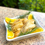 plate of turkey meat with orange slices and rosemary sprigs