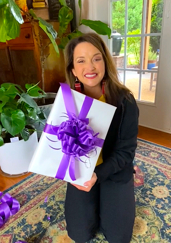 Lara holding a gift with the newly handmade bow