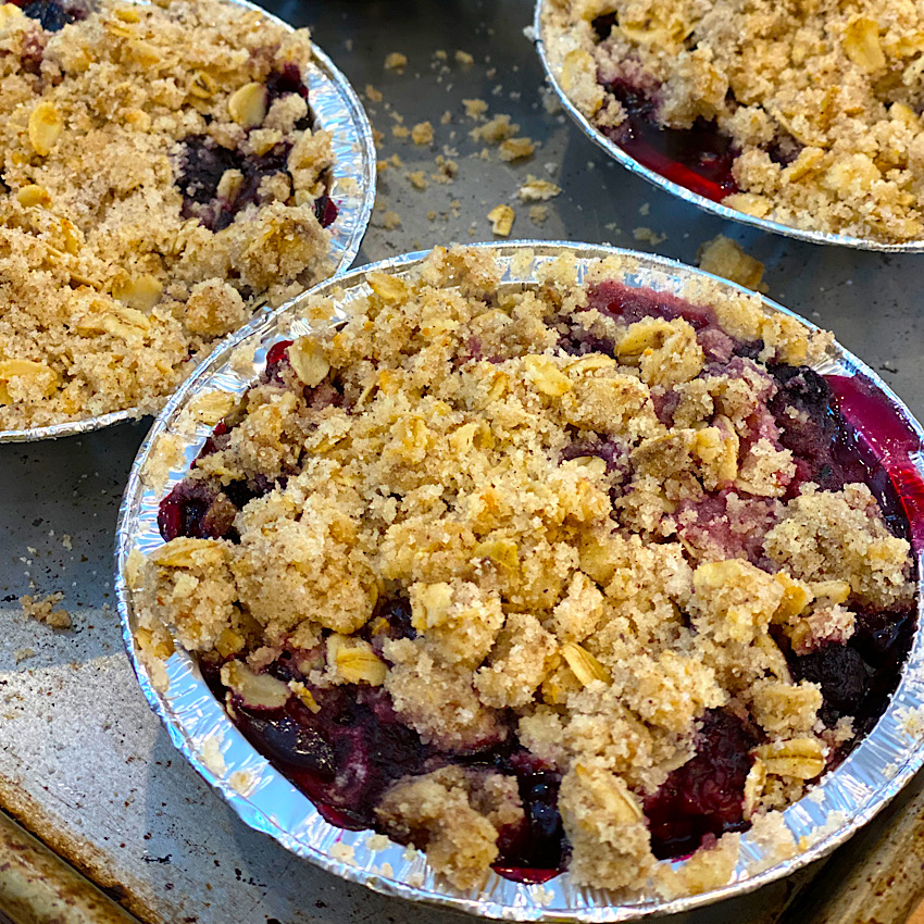 Mini Berry Crisps fresh from the oven. The crumble topping is browned and crunchy and the berries are still bubbling.