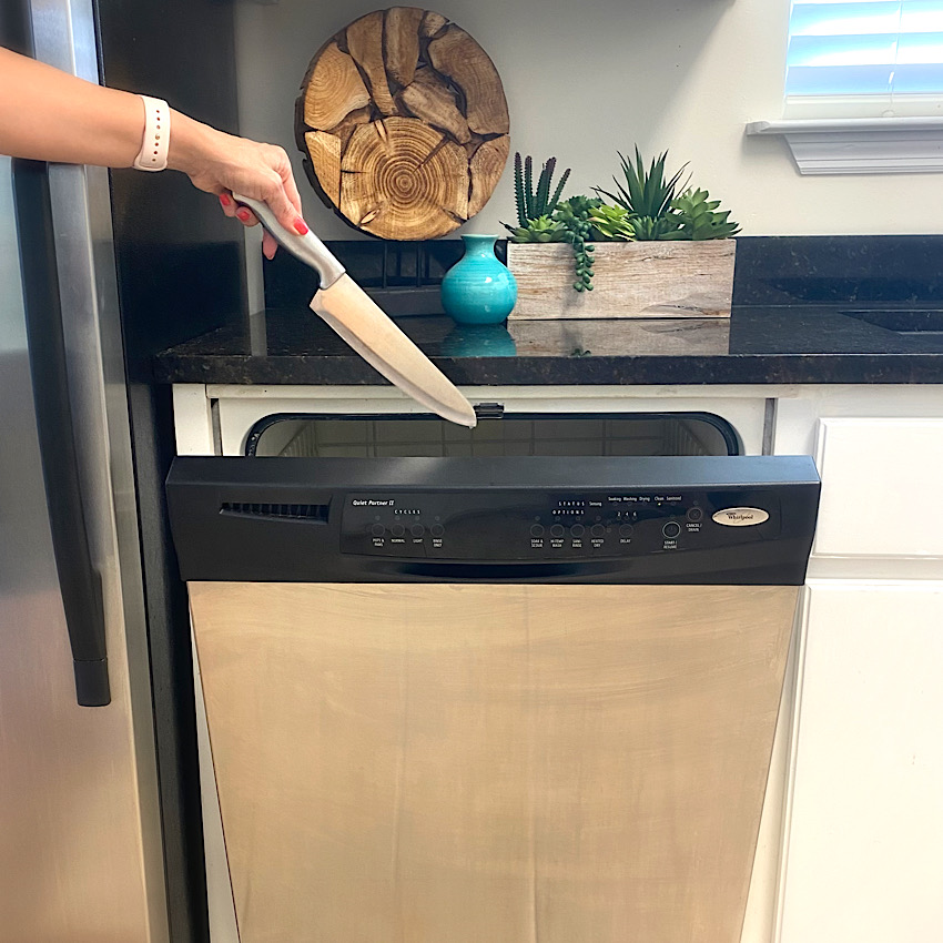 picture of someone putting a knife in a dishwasher