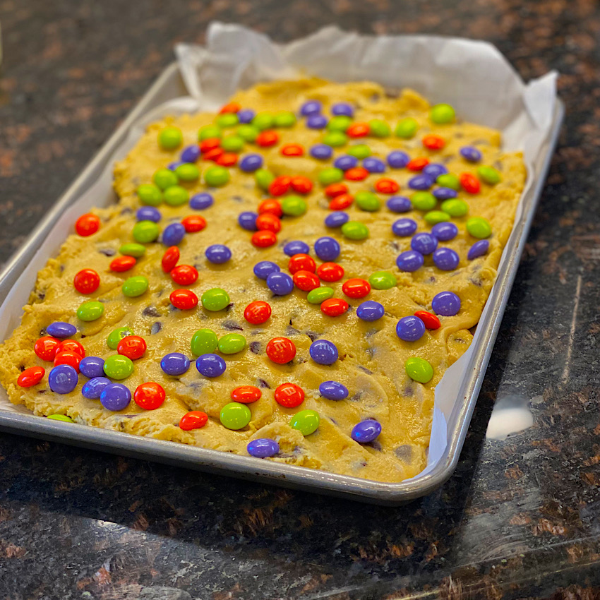 M&M's scattered on top of raw cookie dough before baking